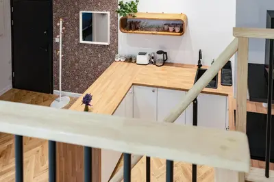 a kitchen and living room with a table and chairs at Tyzenhauz Apartments Siemiradzkiego Street in Kraków