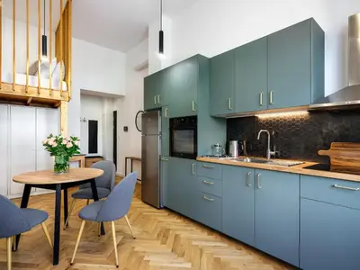 a dining room with a table and a tv at Tyzenhauz Apartments Siemiradzkiego Street in Kraków
