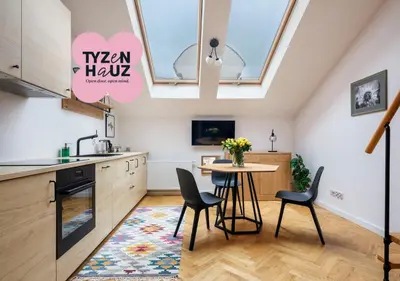 a kitchen with a table with a vase of flowers at Tyzenhauz Apartments Siemiradzkiego Street in Kraków