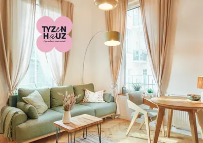 a living room with a blue couch and a wooden staircase at Tyzenhauz Apartments Siemiradzkiego Street in Kraków