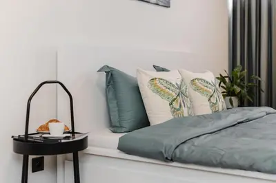 a bedroom with a bed with pillows and a table at NEW place next to Vistula & Wawel Castle in Kraków