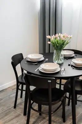 a black table with chairs and a vase of flowers at NEW place next to Vistula & Wawel Castle in Kraków