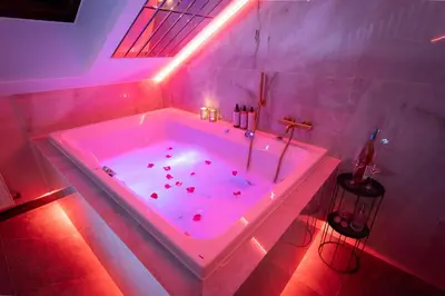 a bathroom with a tub with pink lights in it at Exclusive BDSM Apartment Kraków - ADULTS ONLY in Kraków