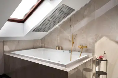 a bath tub in a bathroom with a skylight at Exclusive BDSM Apartment Kraków - ADULTS ONLY in Kraków