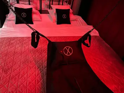 a bedroom with a red bed with black pillows at Exclusive BDSM Apartment Kraków - ADULTS ONLY in Kraków