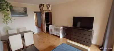 a living room with a crib and a flat screen tv at Radzikowskiego 100B in Kraków