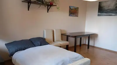 a bedroom with a bed and a table and a chair at Radzikowskiego 100B in Kraków