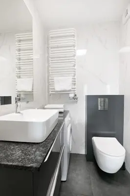 a white bathroom with a sink and a toilet at Apartamenty Platinex 1 in Kraków