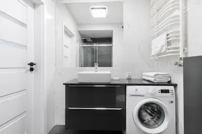 a bathroom with a washing machine and a sink at Apartamenty Platinex 1 in Kraków