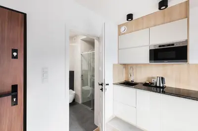 a kitchen with white cabinets and a sink at Apartamenty Platinex 1 in Kraków