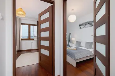a door leading into a bedroom with a bed at Spacious & Cozy Apartment Grzegórzecka by Noclegi Renters in Kraków