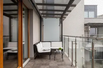 a balcony with a white chair and a table at Spacious & Cozy Apartment Grzegórzecka by Noclegi Renters in Kraków