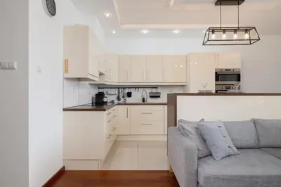 a living room with a couch and a kitchen at Spacious & Cozy Apartment Grzegórzecka by Noclegi Renters in Kraków