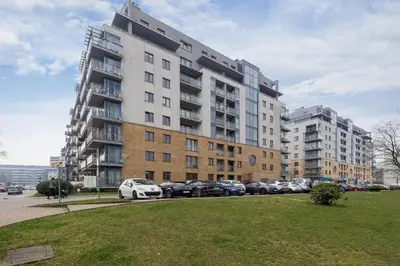 a large building with cars parked in a parking lot at Spacious & Cozy Apartment Grzegórzecka by Noclegi Renters in Kraków