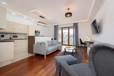 a kitchen and a living room with a couch and a table at Spacious & Cozy Apartment Grzegórzecka by Noclegi Renters in Kraków
