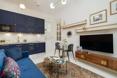 a living room with a blue couch and a tv at Dietla One Bedroom Apartments with Air Conditioning & Balcony by Noclegi Renters in Kraków