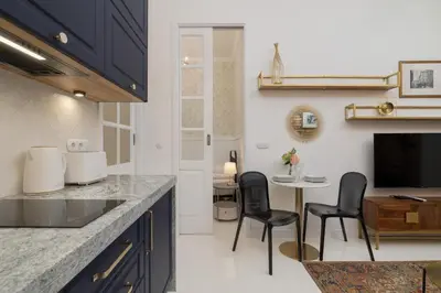 a kitchen with two chairs and a table with a tv at Dietla One Bedroom Apartments with Air Conditioning & Balcony by Noclegi Renters in Kraków