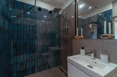 a bathroom with a sink and a shower with a mirror at Apartament Kościuszki 47m44 in Kraków