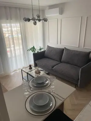 a living room with a couch and a table with plates on it at Imperial Citi Apartament in Kraków