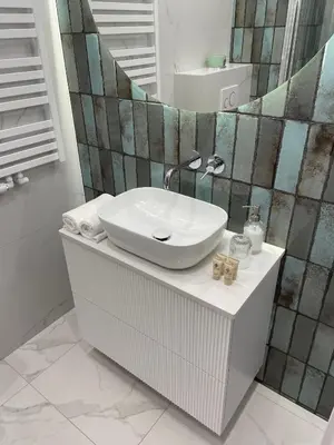 a bathroom with a sink and a mirror at Imperial Citi Apartament in Kraków