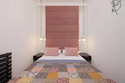 a bedroom with a bed with two pink pillows at Beautiful & Stylish Apartaments Dietla with Air Conditioning by Noclegi Renters in Kraków