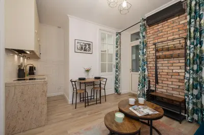 a kitchen and living room with a brick wall at Beautiful & Stylish Apartaments Dietla with Air Conditioning by Noclegi Renters in Kraków