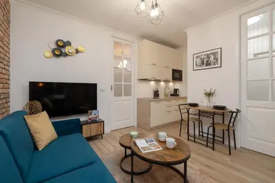 a living room with a blue couch and a table at Beautiful & Stylish Apartaments Dietla with Air Conditioning by Noclegi Renters in Kraków