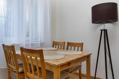a dining room table with chairs and a black lamp at Park Strzelecki Two-Level Apartment by BookingHost in Kraków