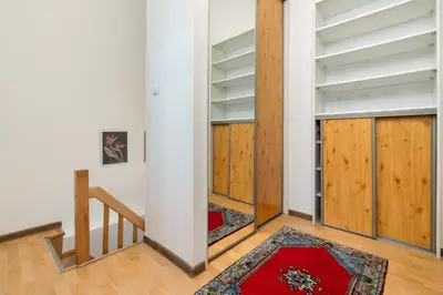 an empty room with wooden doors and a staircase at Park Strzelecki Two-Level Apartment by BookingHost in Kraków