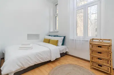 a white bedroom with a bed and a dresser at Park Strzelecki Two-Level Apartment by BookingHost in Kraków