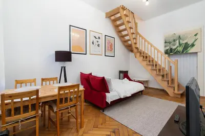 a living room with a dining table and a staircase at Park Strzelecki Two-Level Apartment by BookingHost in Kraków