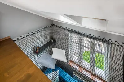 a room with a white chair and a window at Corner House Residence in Kraków