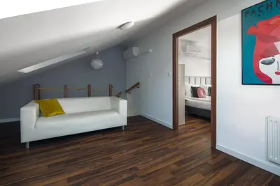a bedroom with a white couch and a mirror at Corner House Residence in Kraków