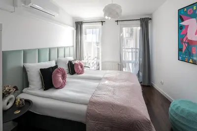 a bedroom with a large bed with pink pillows at Corner House Residence in Kraków