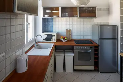 a small kitchen with a sink and a refrigerator at Corner House Residence in Kraków