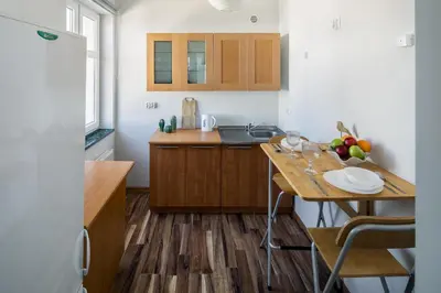 a kitchen with wooden cabinets and a wooden table at Corner House Residence in Kraków