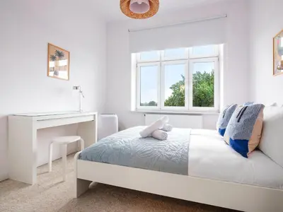 a white bedroom with a bed and a desk at Castle View Apartments by Tyzenhauz in Kraków