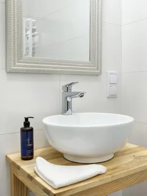a bathroom with a white sink and a mirror at Castle View Apartments by Tyzenhauz in Kraków