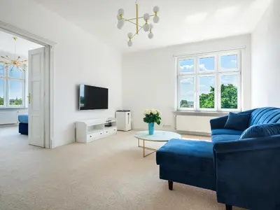 a living room with a blue couch and a tv at Castle View Apartments by Tyzenhauz in Kraków