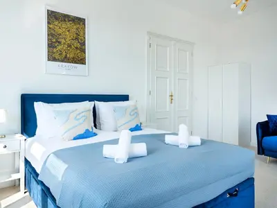 a blue and white bedroom with a large bed at Castle View Apartments by Tyzenhauz in Kraków