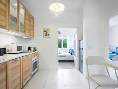a kitchen with white walls and wooden cabinets at Castle View Apartments by Tyzenhauz in Kraków