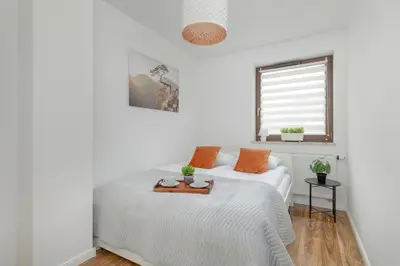 a white bedroom with a bed and a window at Apartment with Garden in Kraków by Noclegi Renters in Kraków