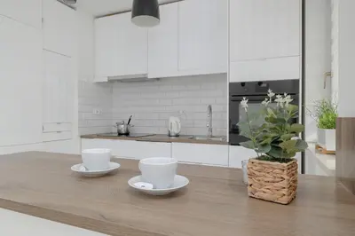 a kitchen with two cups on a wooden table at Apartment with Garden in Kraków by Noclegi Renters in Kraków