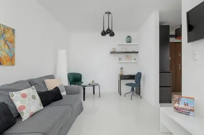 a living room with a gray couch and a table at Apartment with Garden in Kraków by Noclegi Renters in Kraków
