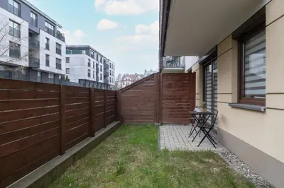 a backyard with a fence and a table in the grass at Apartment with Garden in Kraków by Noclegi Renters in Kraków