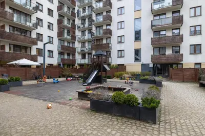a playground in front of a large apartment building at Apartment with Garden in Kraków by Noclegi Renters in Kraków