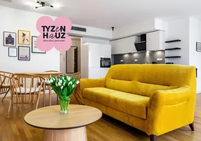 a living room with a yellow couch and a table at Modern Central Apartment w. parking by Tyzenhauz in Kraków