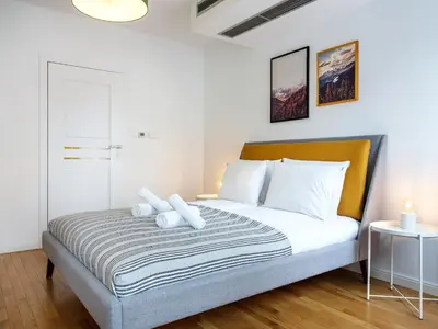 a bedroom with a bed with white pillows at Modern Central Apartment w. parking by Tyzenhauz in Kraków