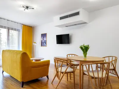 a dining room with a table and a yellow chair at Modern Central Apartment w. parking by Tyzenhauz in Kraków