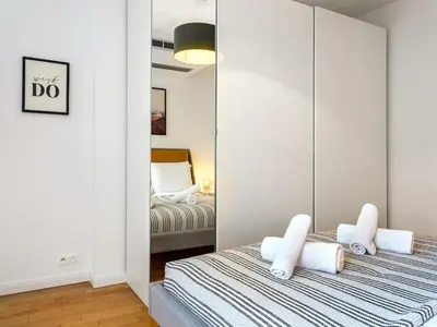 a bedroom with two beds and a mirror at Modern Central Apartment w. parking by Tyzenhauz in Kraków